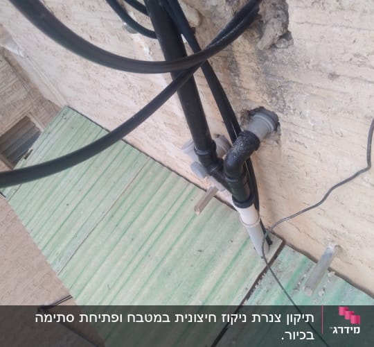 צינורות שחורים מחוברים לקיר חיצוני